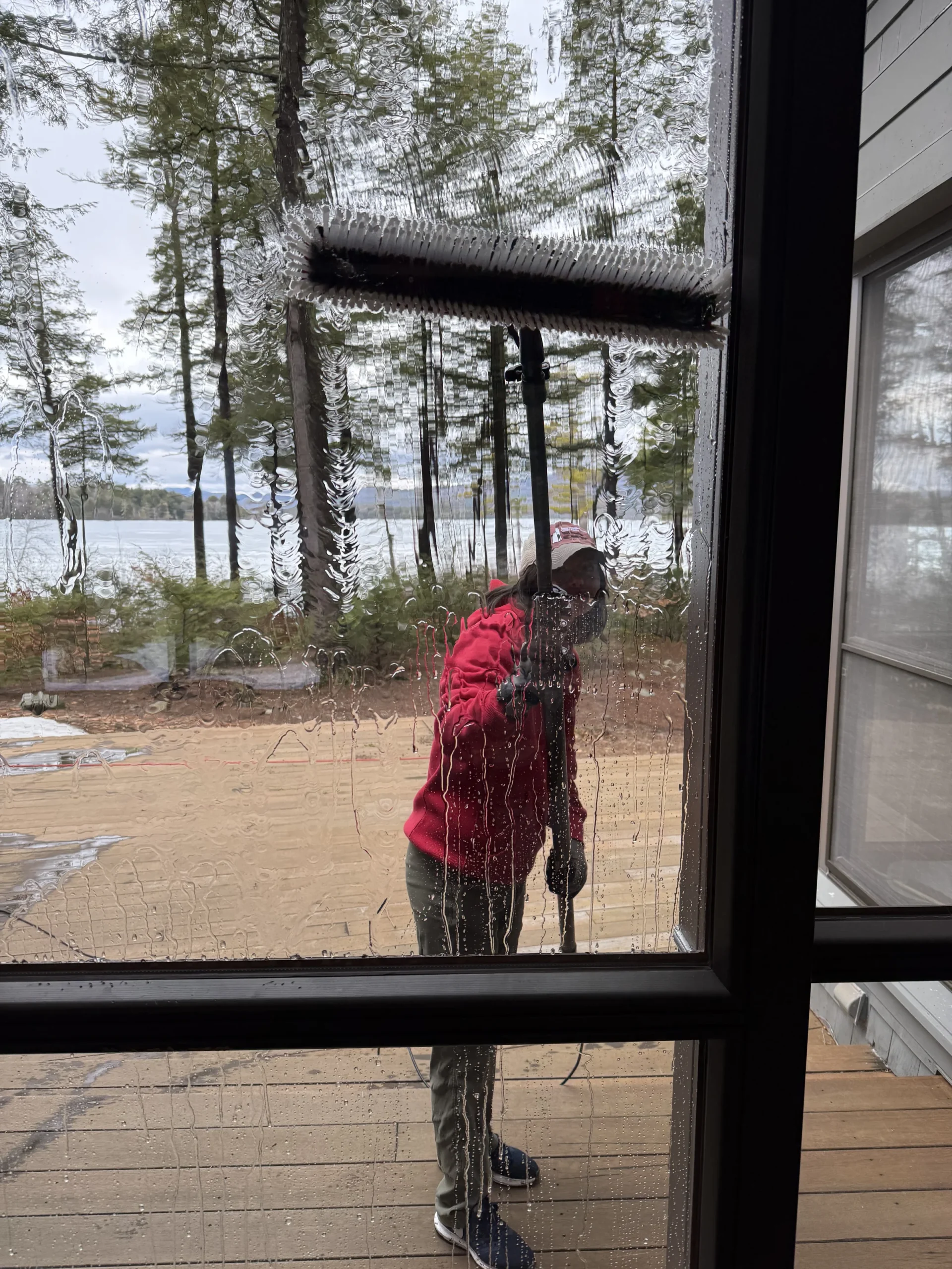 A Streak Free or Die technician carefully cleans glass panes for streak-free, crystal-clear windows.